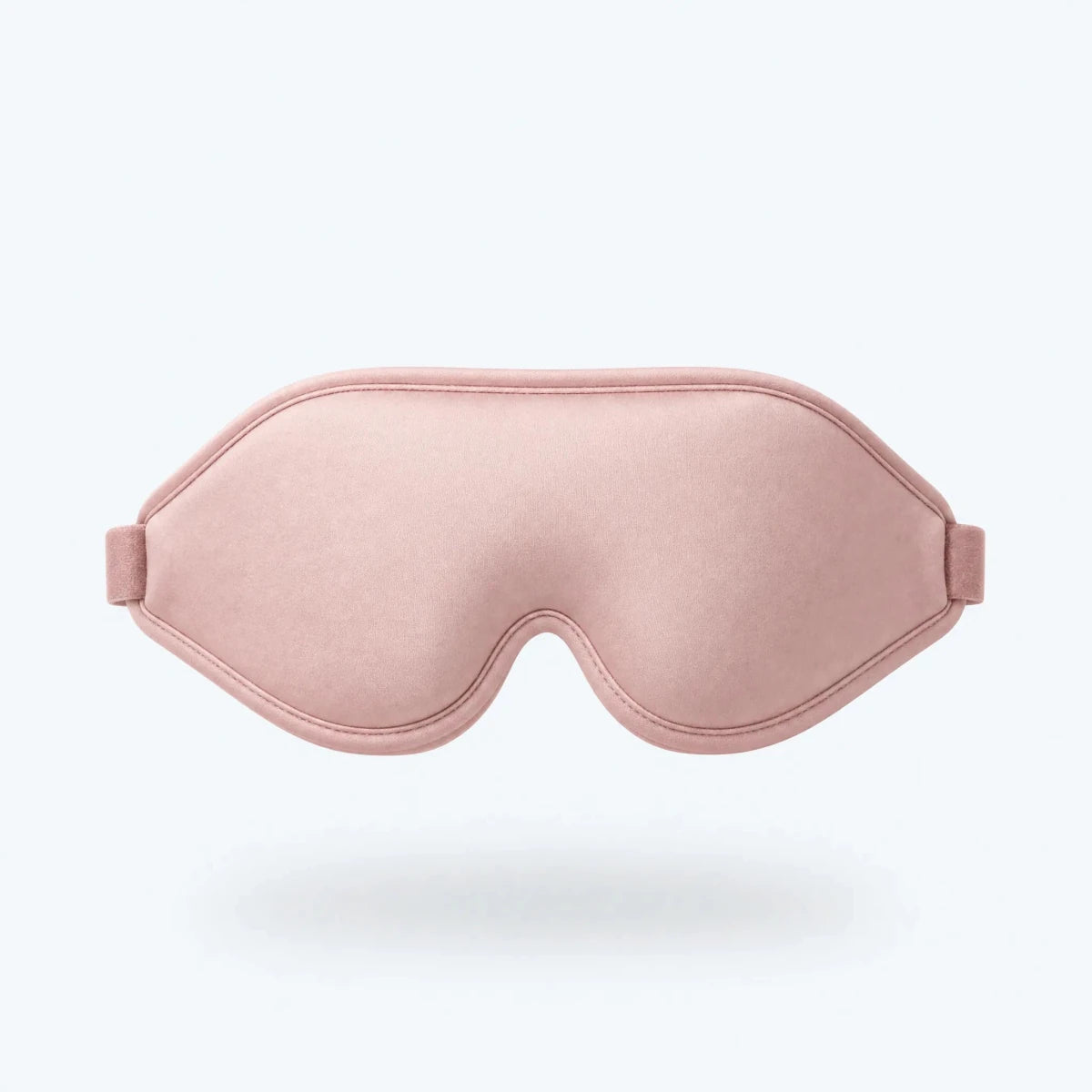 Blush pink contoured sleep mask shown floating against a plain background